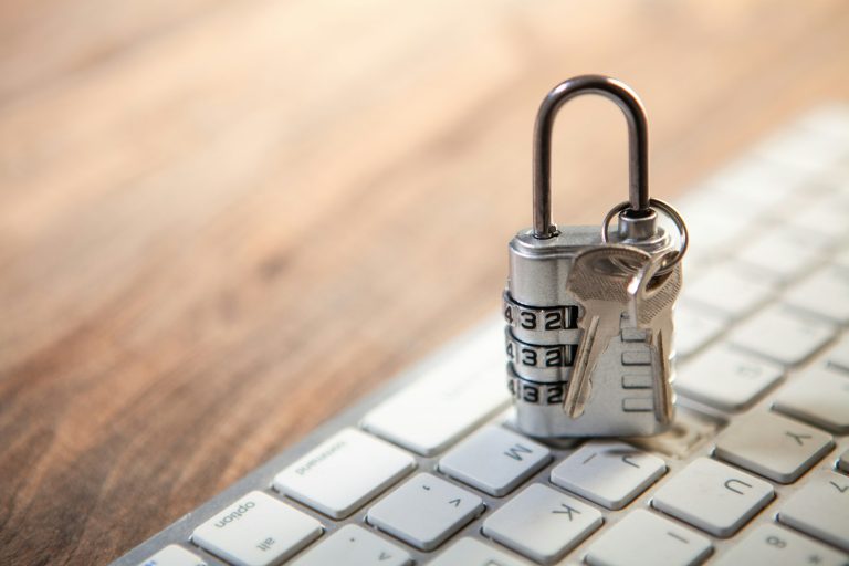 Padlock and keys resting on a computer keyboard, representing layered account security